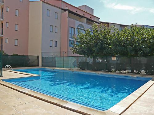 une grande piscine bleue devant un immeuble dans l'établissement BAIE DES ANGES I Agréable 2 pièces cabine résidence avec piscine vue lagon Richelieu Cap d'Agde, au Cap d'Agde