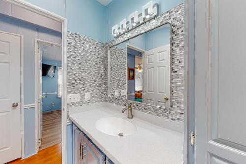 a bathroom with a sink and a mirror at Assateague Pointe ---12401 Windlass Way in Berlin