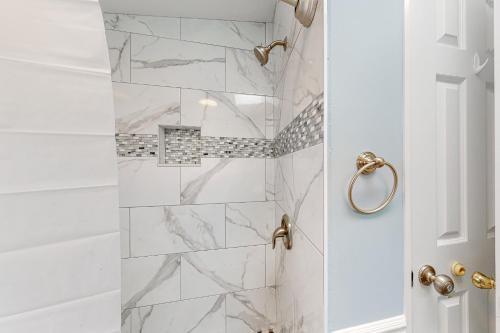 a bathroom with a shower with white marble tiles at Assateague Pointe ---12401 Windlass Way in Berlin
