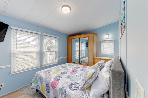 a bedroom with a bed and blue walls and windows at Assateague Pointe ---12401 Windlass Way in Berlin