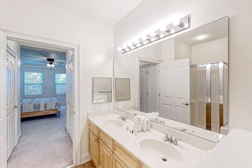 a white bathroom with a sink and a mirror at Havens 1123 in North Myrtle Beach