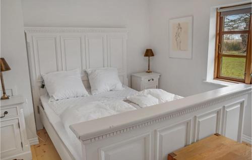 Awesome Home In ster Ulslev With Kitchen في Øster Ulslev: سرير أبيض مع أغطية ووسائد بيضاء