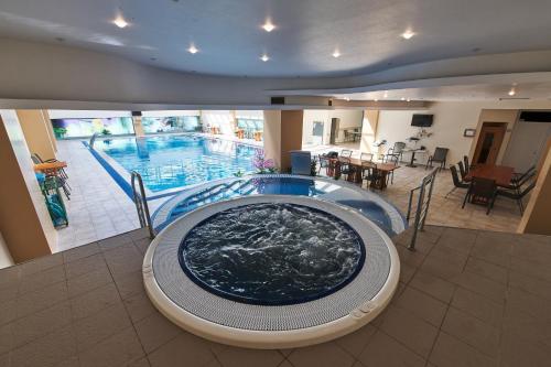 a large swimming pool with a large tub in a building at Hotel EMD in Bacău