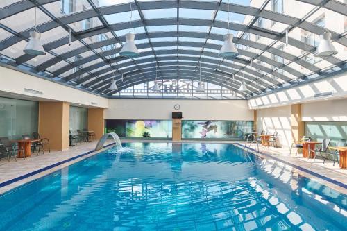 a large swimming pool with a glass ceiling at Hotel EMD in Bacău