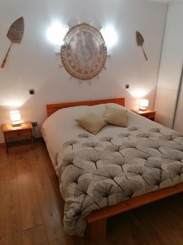 a bedroom with a large bed with two night stands at Le gîte du Moulin in Lagardelle-sur-Lèze