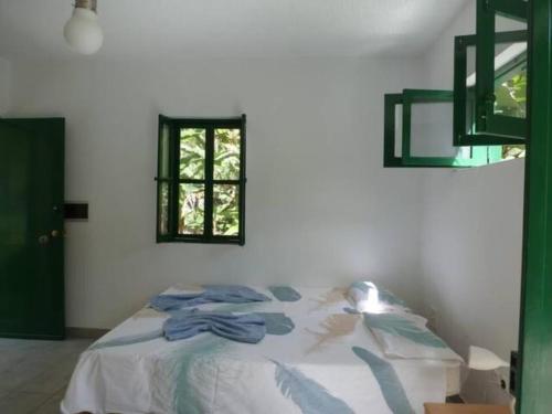 Cama en habitación blanca con ventana en Cottage na Ribeira do Paúl en Pombas