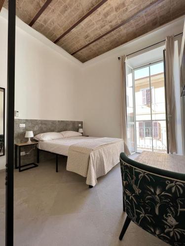 a bedroom with a bed and a large window at Al Vicolo in Terracina