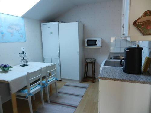 a kitchen with a white refrigerator and a sink at Tupaniemi, kodikas ja tilava asunto 2-4 vieraalle in Pori