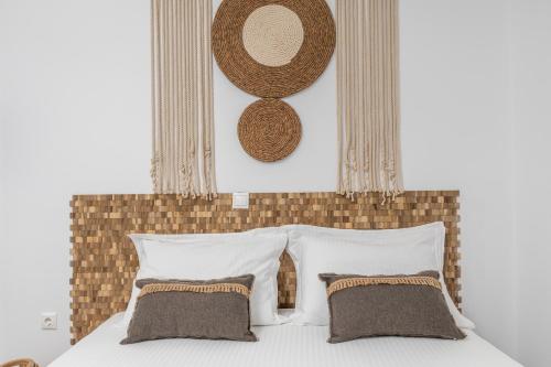 1 cama con almohadas blancas y cabecero marrón en Kalliston Naxos, en Akrotiri