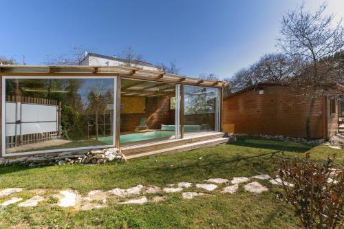 a house with a large glass window in the yard at Rural Cottage in Alfeizerão
