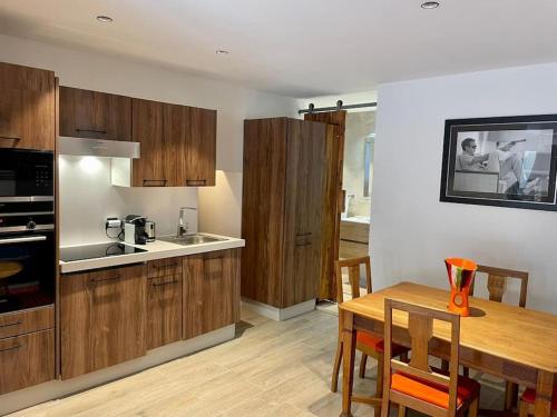 une cuisine avec des placards en bois et une table en bois avec des chaises dans l'établissement Superbe appartement près de la plage et du centre ville, à Saint-Tropez