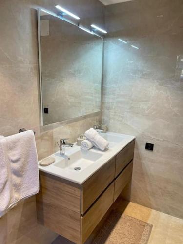 une salle de bain avec un lavabo et un miroir dans l'établissement Superbe appartement près de la plage et du centre ville, à Saint-Tropez