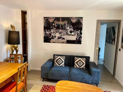 un salon avec un canapé bleu et une table dans l'établissement Superbe appartement près de la plage et du centre ville, à Saint-Tropez