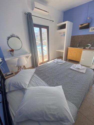 a bedroom with a bed with a mirror and a sink at Stella Nomikou Apartments in Firostefani