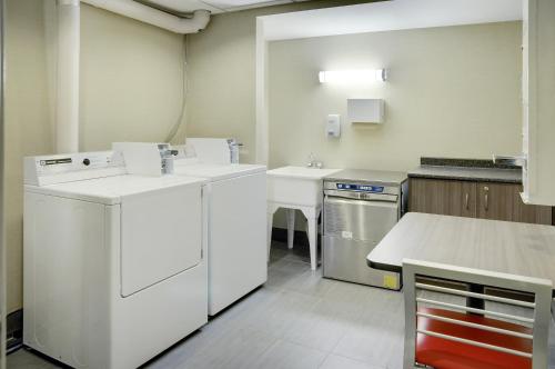 uma cozinha com electrodomésticos brancos e um lavatório em Quality Inn em North Bay
