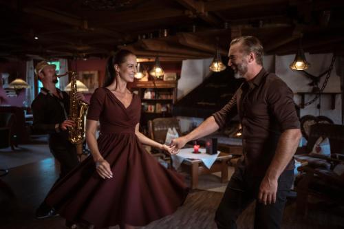a man and a woman in a dress dancing at Kirchenwirt in Reith im Alpbachtal