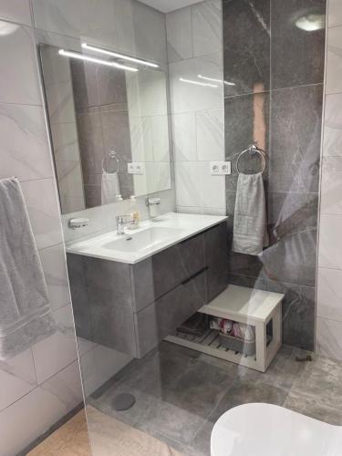 a bathroom with a sink and a shower with a mirror at ESQUINZO POOL & BEACH in Playa Jandia