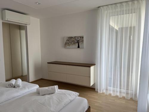 Habitación blanca con 2 camas y ventana en Luxusappartement mit Garage im Zentrum, en Wiener Neustadt