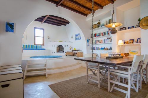 a kitchen and dining room with a table and chairs at IosVilla at Sapounohoma in Mylopotas