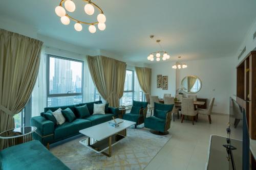 a living room with a blue couch and a table at INA Homes-Residences Tower 7 Full Burj Khalifa & Fountain Views in Dubai