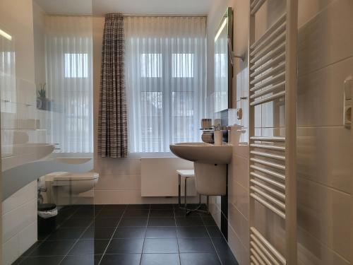 La salle de bains est pourvue d'un lavabo et de toilettes. dans l'établissement Ferienwohnung Jung, à Sankt Peter-Ording