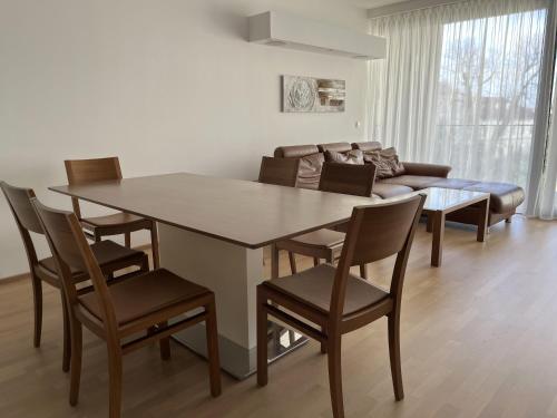 a dining room with a table and chairs and a couch at Luxusappartement mit Garage im Zentrum in Wiener Neustadt