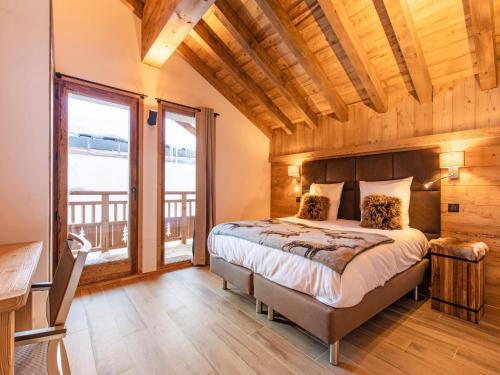 a bedroom with a bed and a large window at Prestigious chalet with pool and sauna in Champagny-en-Vanoise