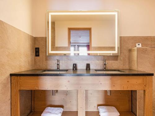 a bathroom with two sinks and a large mirror at Prestigious chalet with pool and sauna in Champagny-en-Vanoise
