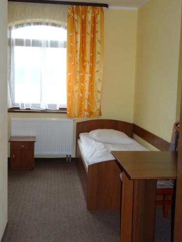 a small bedroom with a bed and a window at Hostel Miłosz in Grabowiec