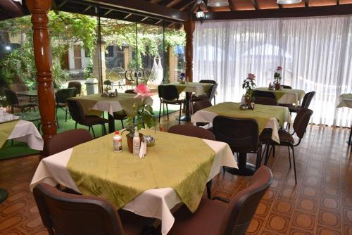 een restaurant met tafels en stoelen met groene tafelkleden bij Hotel Arthur Shambala in Encarnación