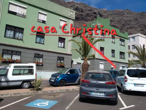 a building with cars parked in a parking lot at casa Christina in Puerto de Tazacorte