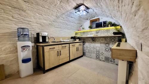a kitchen with an archway in a stone wall at Lumiere House Sibiu in Sibiu
