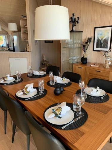 a wooden table with plates and glasses on it at Paradise near Reykjavik w. Sauna - Northern Lights in Mosfellsbær