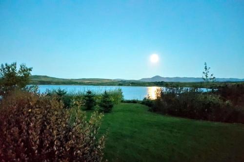 a view of a lake with the moon in the sky at Paradise near Reykjavik w. Sauna - Northern Lights in Mosfellsbær