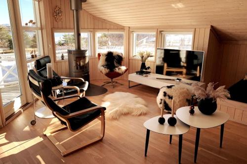 sala de estar con sillas, sofá y TV en Paradise near Reykjavik w. Sauna - Northern Lights, en Mosfellsbær