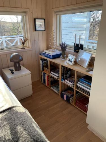 a room with a book shelf with books and a window at Paradise near Reykjavik w. Sauna - Northern Lights in Mosfellsbær