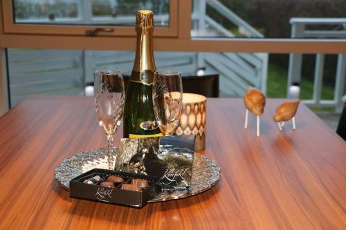a bottle of champagne and two glasses on a table at Paradise near Reykjavik w. Sauna - Northern Lights in Mosfellsbær