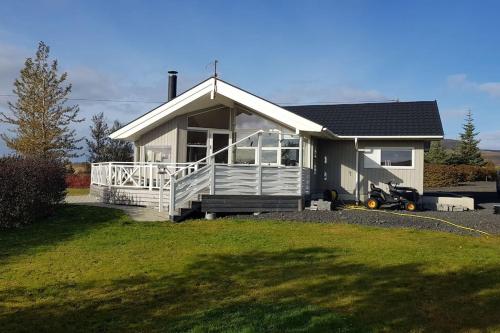 a small white house with a porch and a yard at Paradise near Reykjavik w. Sauna - Northern Lights in Mosfellsbær