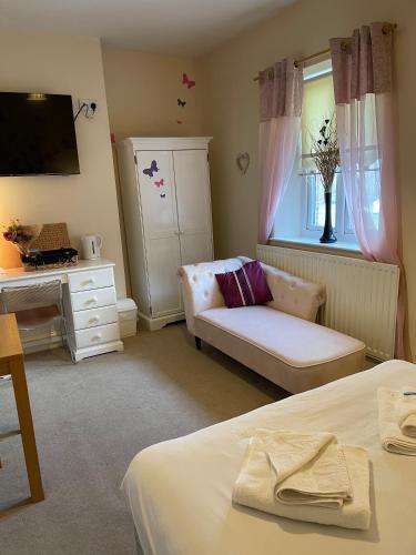 a bedroom with a bed and a couch and a window at The Old Rectory in Jarrow