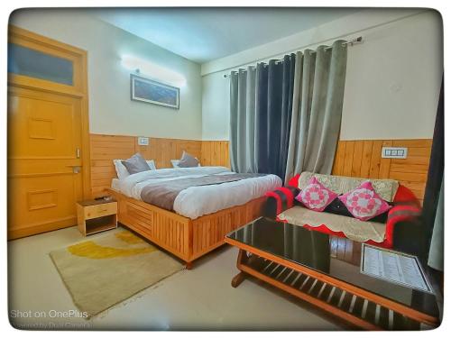 a hotel room with a bed and a couch at Kullu Manali Homestay in Kulu