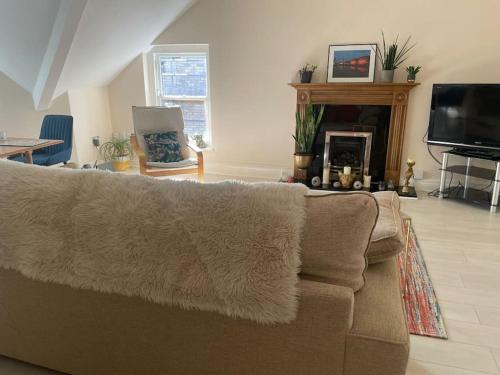 a living room with a couch and a fireplace at Stunning Liverpool Apartment in Liverpool