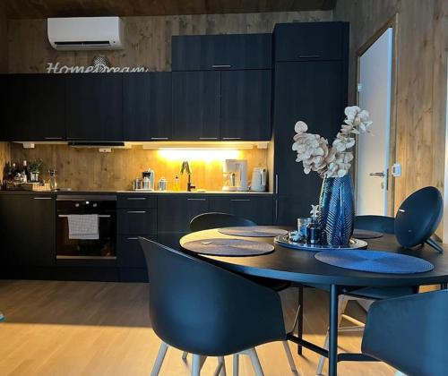 een eetkamer met een tafel en stoelen en een keuken bij Attraktiv & smart funkishytte på Nes Strandhager. in Årnes