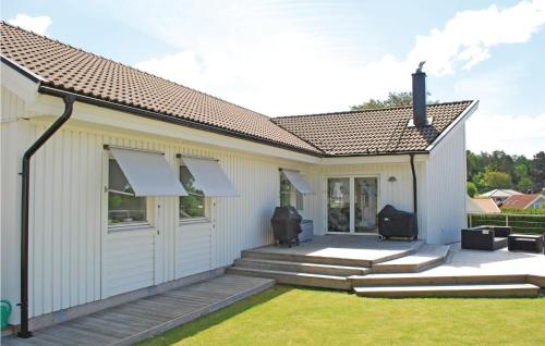 a detached house with a patio and lawn at Amazing Home In Västra Frölunda in Västra Frölunda
