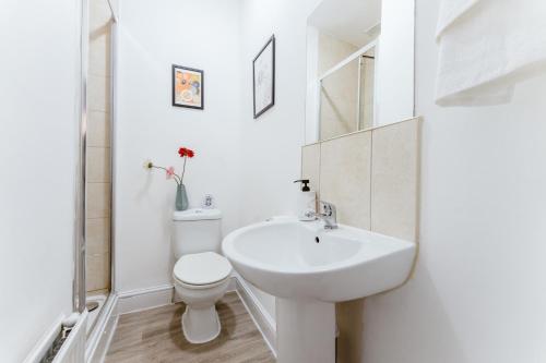 a white bathroom with a toilet and a sink at Mile end Double rooms 86a in London