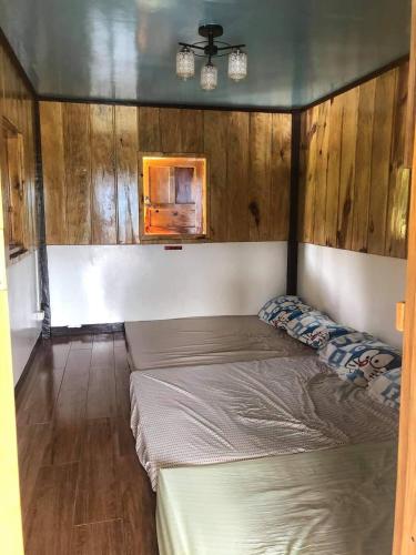 een slaapkamer met 2 bedden in een kamer met houten wanden bij GL's Crib & Coffee 