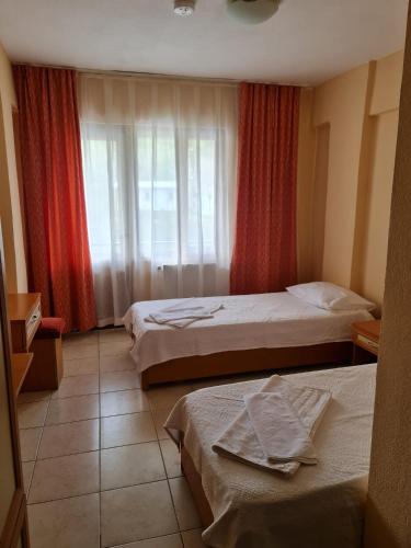 a hotel room with two beds and a window at Caner Mountain Hotel in Antalya