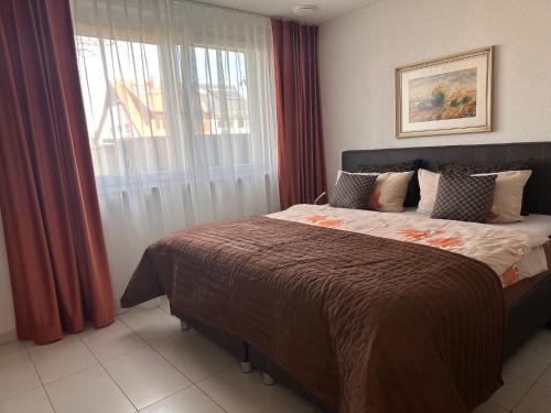 a bedroom with a bed with red curtains and a window at FeWo Michaela Köst in Konstanz