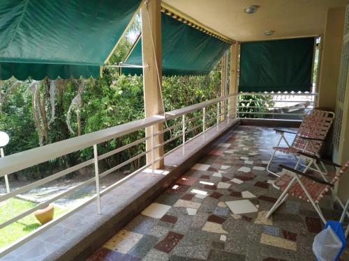 a room with a balcony with chairs and windows at Casa Al pie del Cerro in Yerba Buena