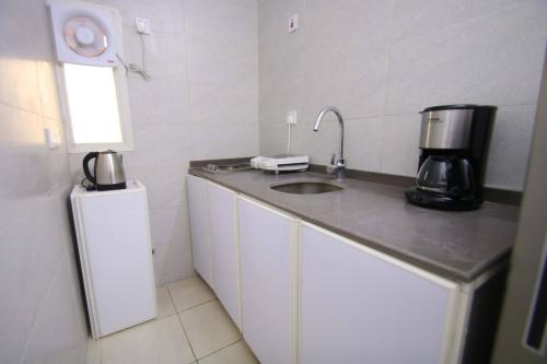 a kitchen with a sink and a coffee maker on a counter at شقق المصيف للشقق المخدومة in Abha