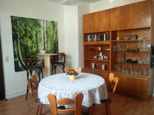 a dining room table with a vase of flowers on it at Ferienwohnung Zur Weißen Taube in Dobbertin
